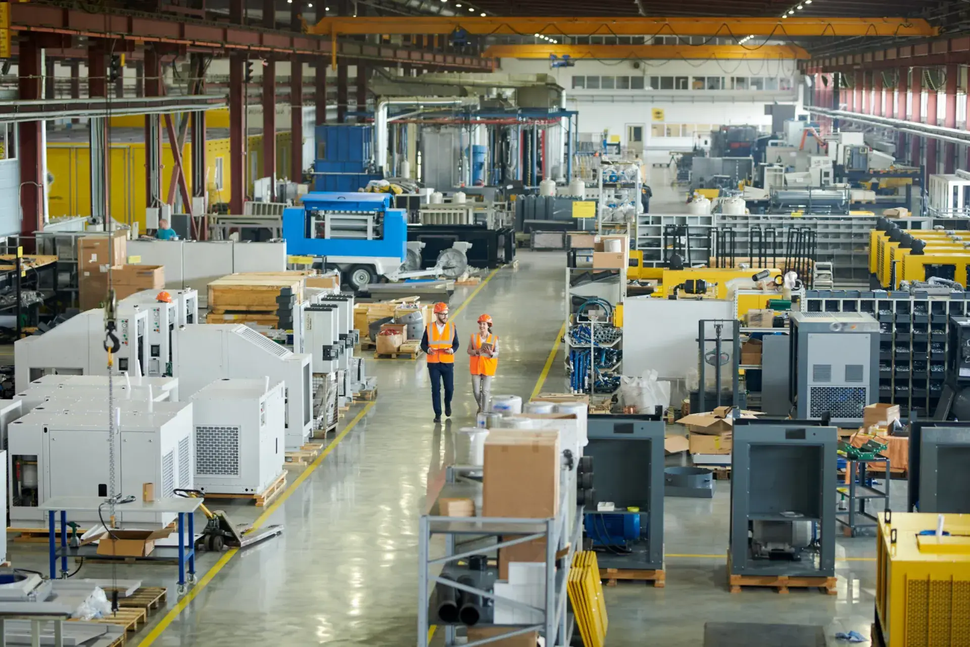 Factory floor with production machinery and workers in safety vests