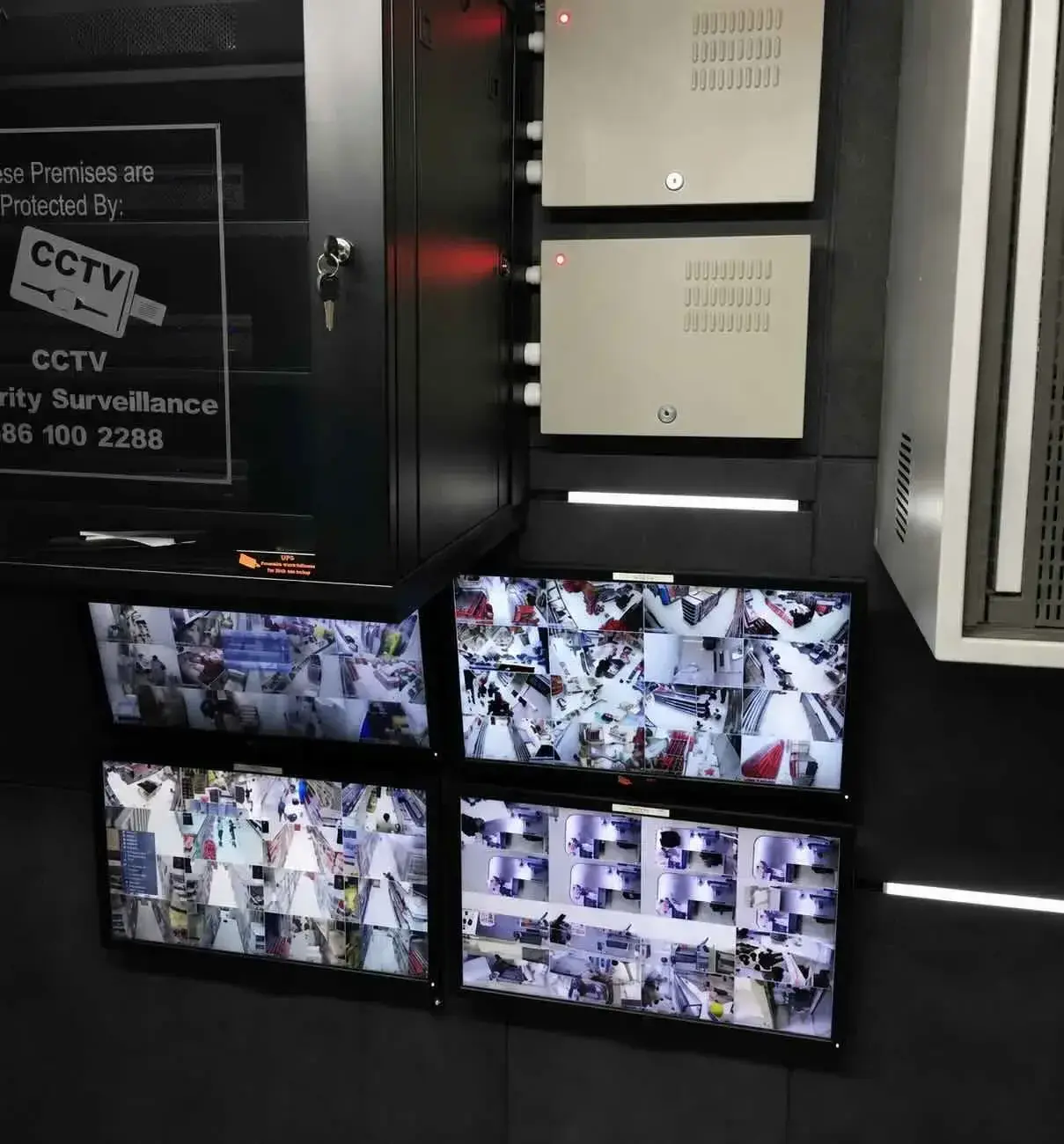 Integrated CCTV system: equipment cabinet with a 'Protected by CCTV Security Surveillance' sign above four live camera monitors