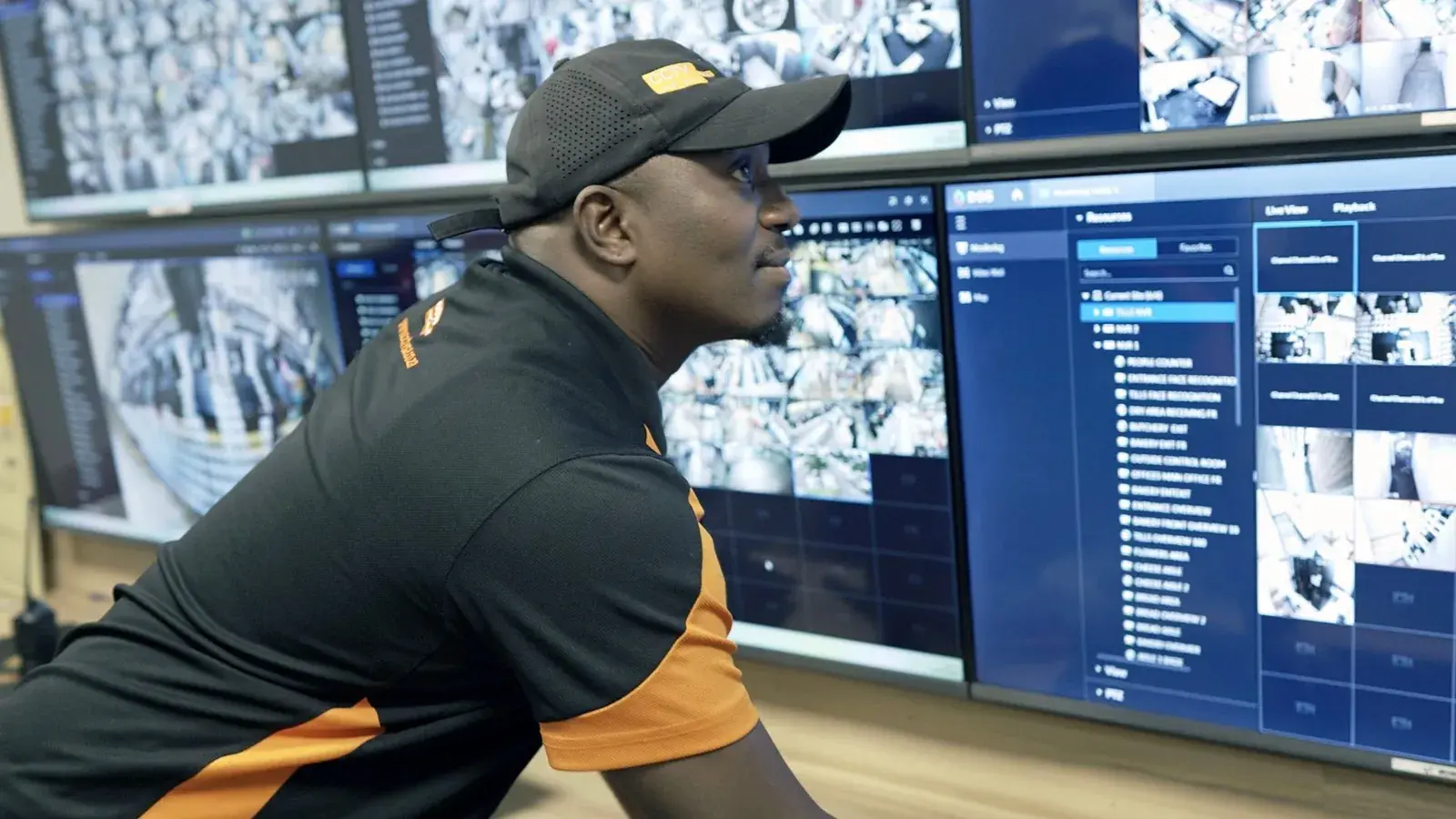 CCTV Security Surveillance technician watching live camera feeds on a CCTV control room video wall